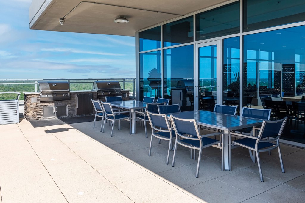 A table with chairs is on a patio at Two Twelve Clayton Apartments, Clayton, MO, 63105