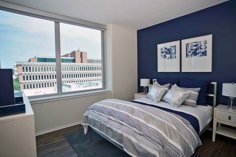 A bedroom with a large bed and a view of the city.