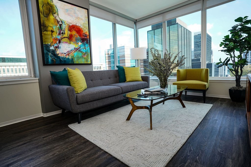 A living room with a grey couch and yellow pillows at Two Twelve Clayton Apartments, Clayton