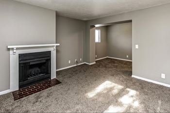 a living room with a fireplace and a carpeted floor