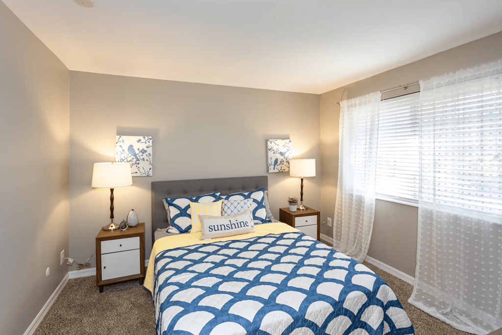 A bedroom with a bed, nightstands, and lamps.