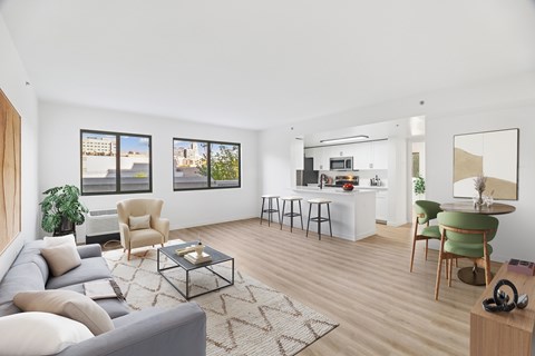 A living room with a grey couch, a coffee table, and a dining table with chairs.