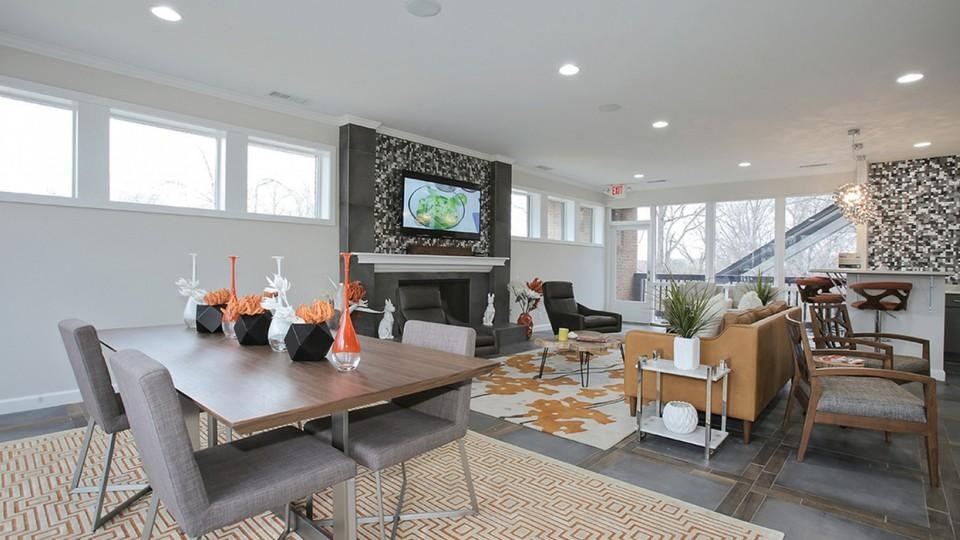 A modern dining room with a wooden table and grey chairs.