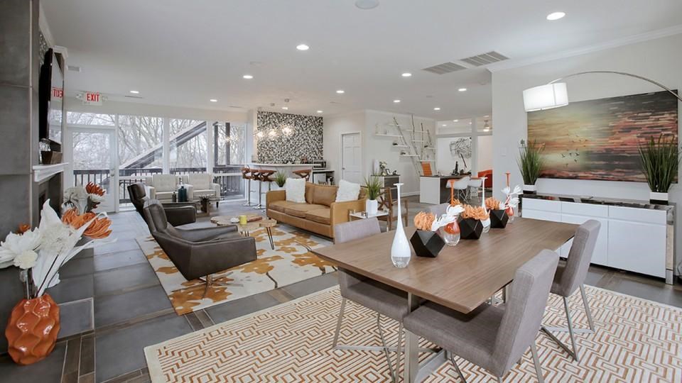 A modern living room with a dining table and chairs.