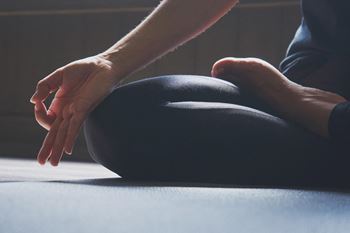 a person sitting on the floor with their hands on their knees