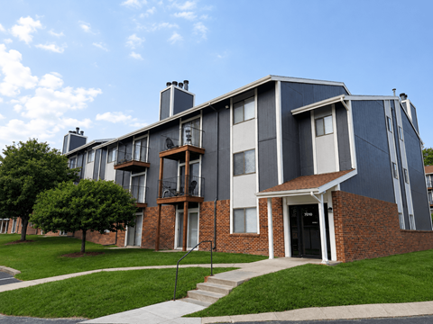 A modern two-story apartment building with a brick base and grey upper floors.