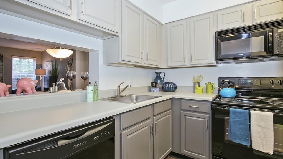 A kitchen with a black oven and a black microwave.