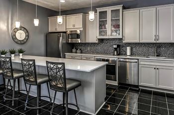 a kitchen with a counter and three chairs