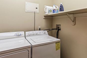 a washer and dryer in a laundry room with a shelf above it