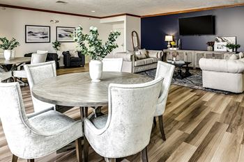 a living room and dining room with white chairs and a table