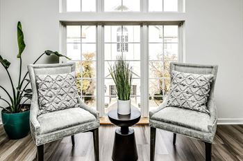 a living room with two chairs and a window