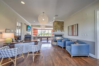 a living room with blue couches and chairs and a fireplace