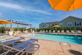a swimming pool with chairs and umbrellas at a resort