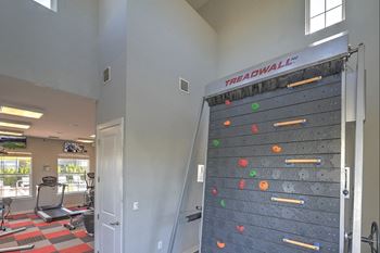 a gym with a rock climbing wall in the corner
