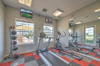 a gym with exercise equipment and windows at the community