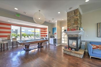 a large living room with a fireplace and a pool table