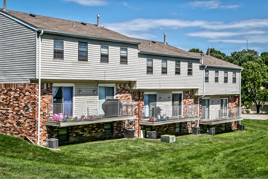 a large white house with a brick facade and a balcony
