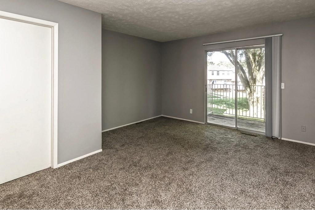 an empty living room with a door to a patio