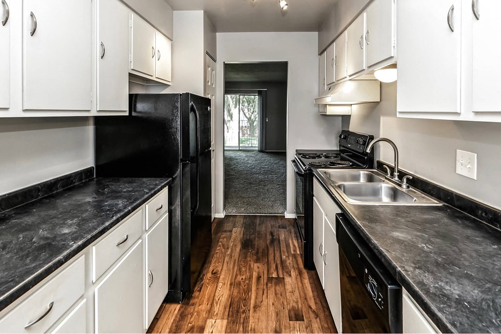 a kitchen with black counter tops and white cabinets