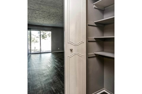the living room of an apartment with a door to the balcony