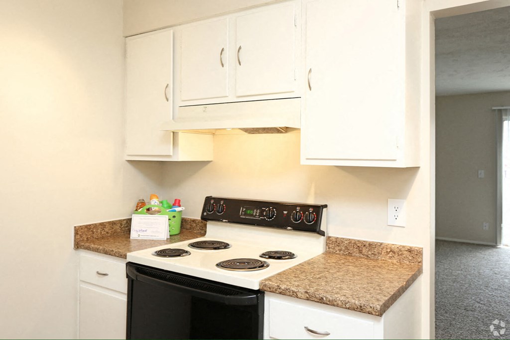a kitchen with white cabinets and a stove top oven