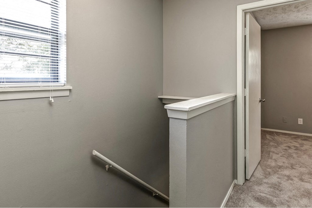 an empty room with a door to a hallway with a window