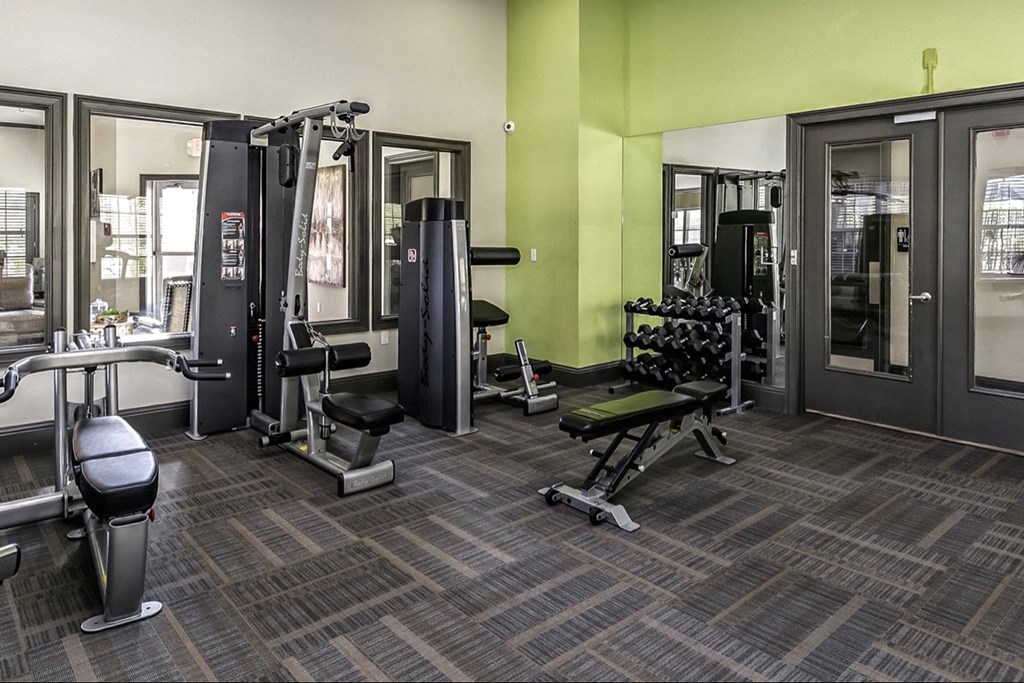 a gym with weights and cardio equipment at the monarch apartments in midtown