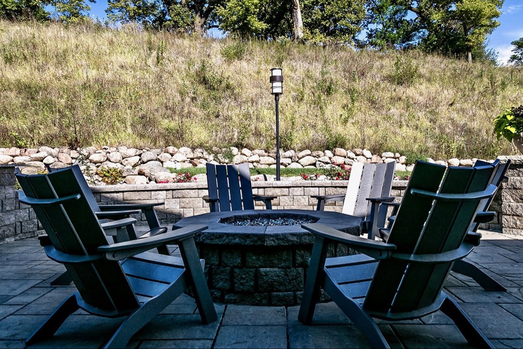 a patio with chairs and a table and a fire pit
