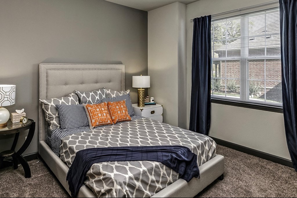 a bedroom with a bed and a large window