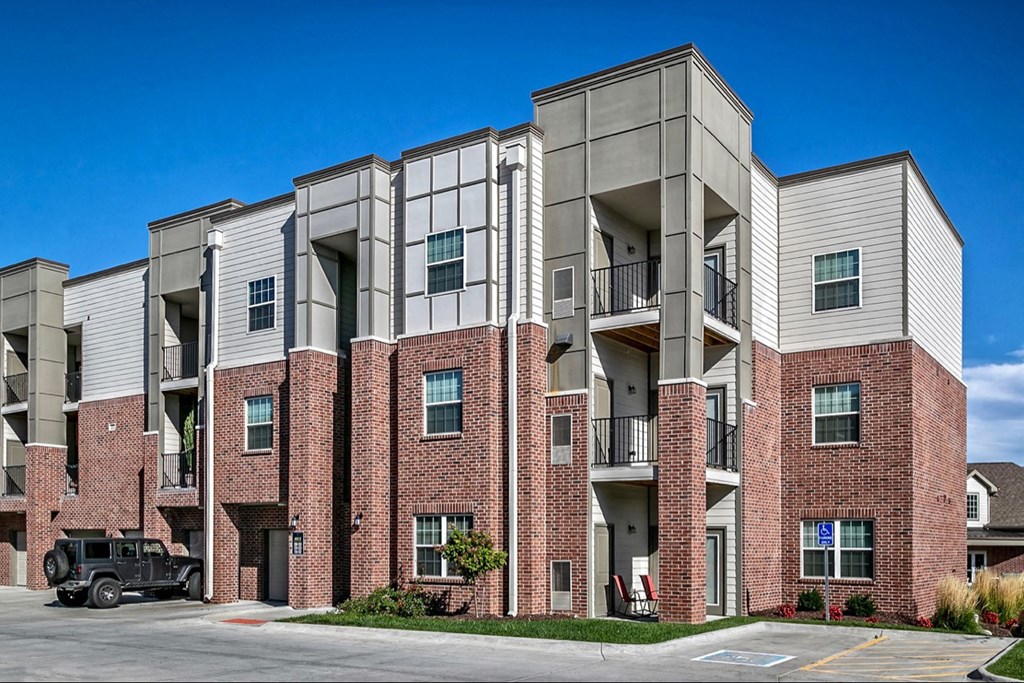 a red brick apartment building with a black truck parked in front of it