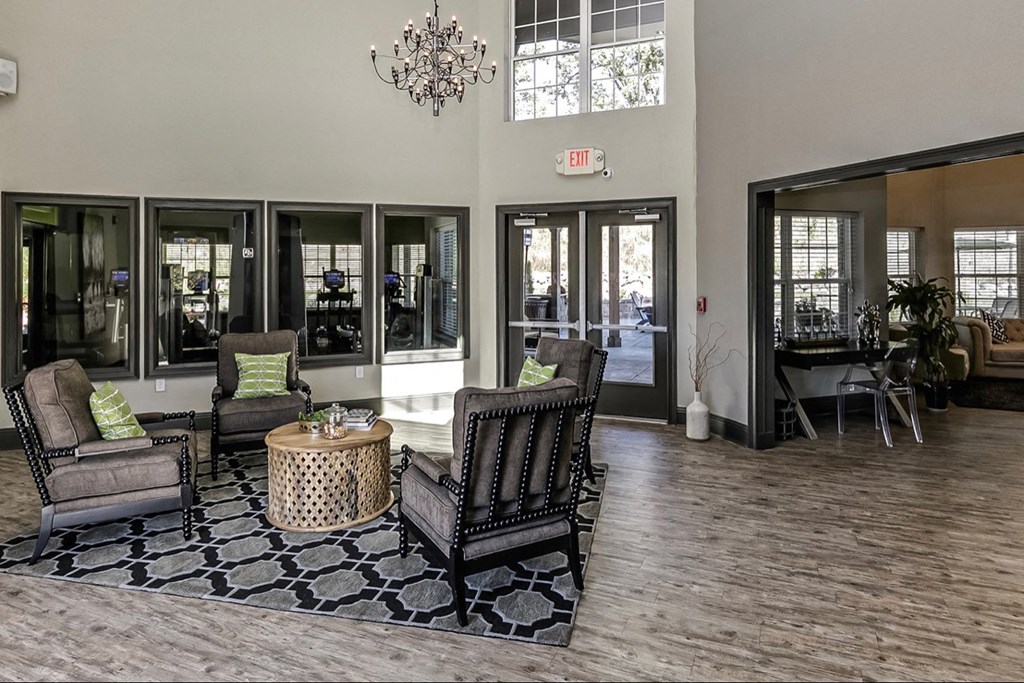a lobby with chairs and a table and a chandelier
