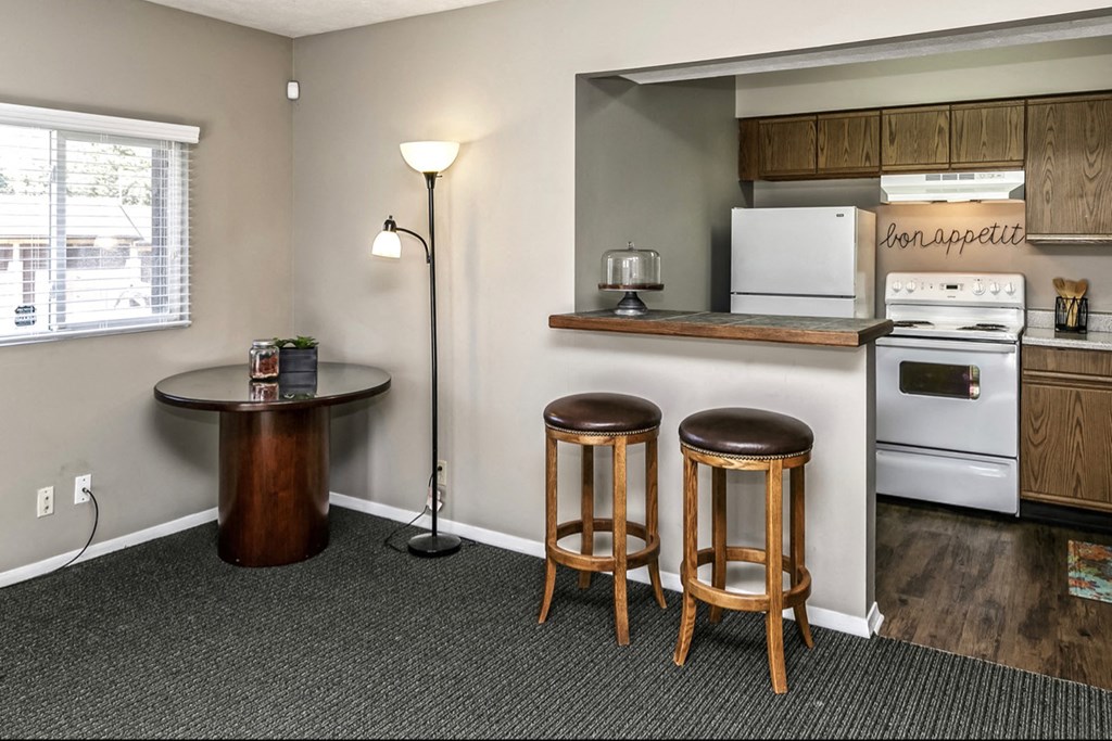 a kitchen with a stove and a counter with two stools