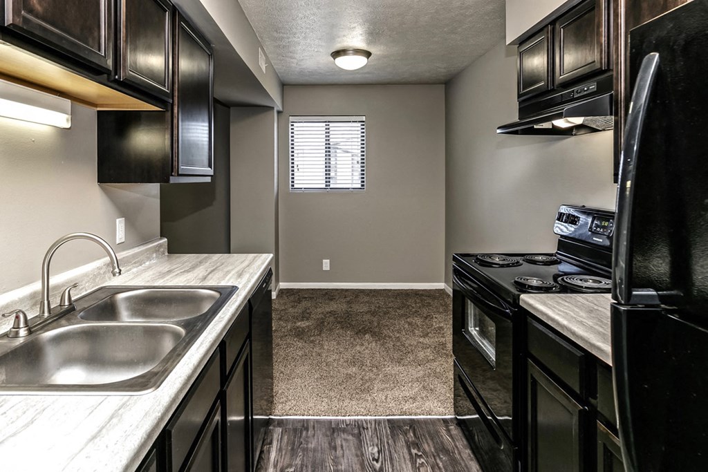 the kitchen of a home with black appliances and a sink