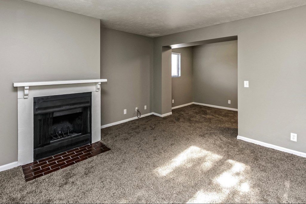 an empty living room with a fireplace