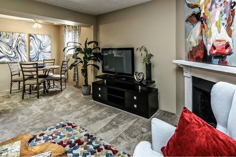 A living room with a television, a fireplace, and a painting of a cow on the wall.