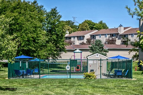 a yard with a playground and a house in the background