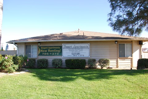 A house with a sign that says "Bogart Apartments Now Renting!".
