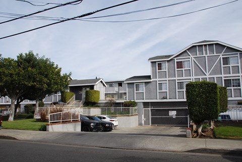 A black car is parked in front of a white building.