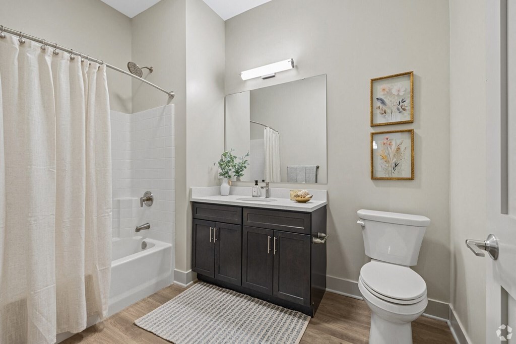 A bathroom with a white toilet, a white sink, and a white shower curtain.