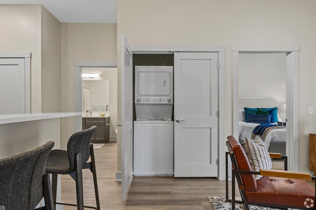 A kitchen area with a refrigerator, microwave, and a dining table with chairs.