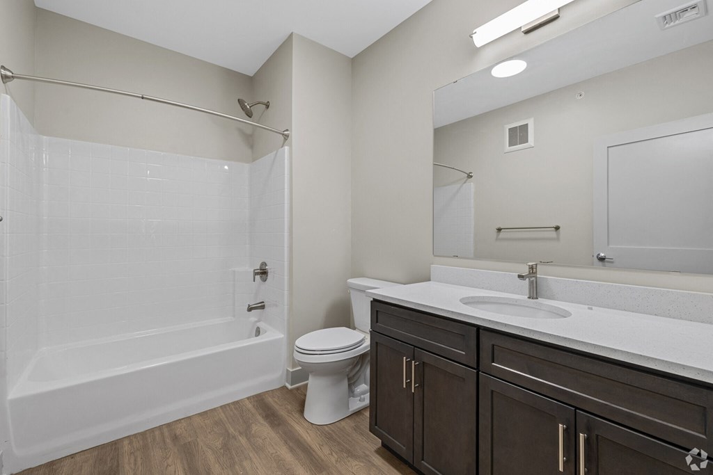 A white bathroom with a toilet, sink, and shower.