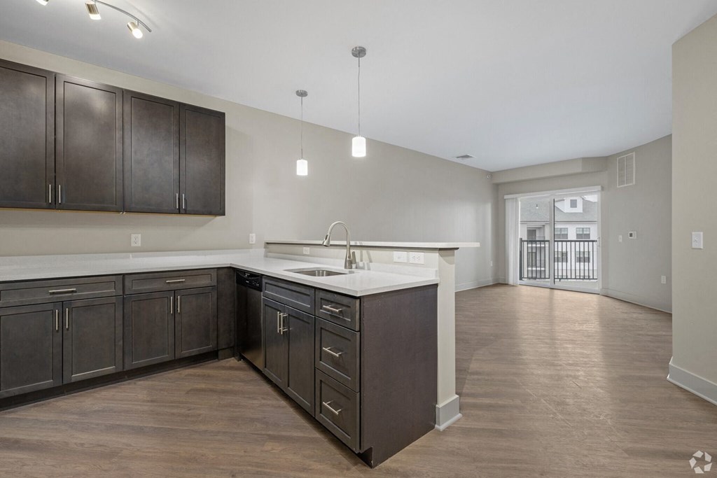 A kitchen with dark brown cabinets and a white countertop.