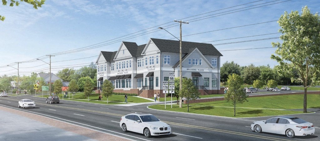 A white car is driving on a street past a house.