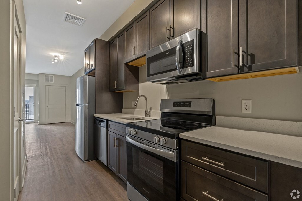 A kitchen with dark wood cabinets and stainless steel appliances.