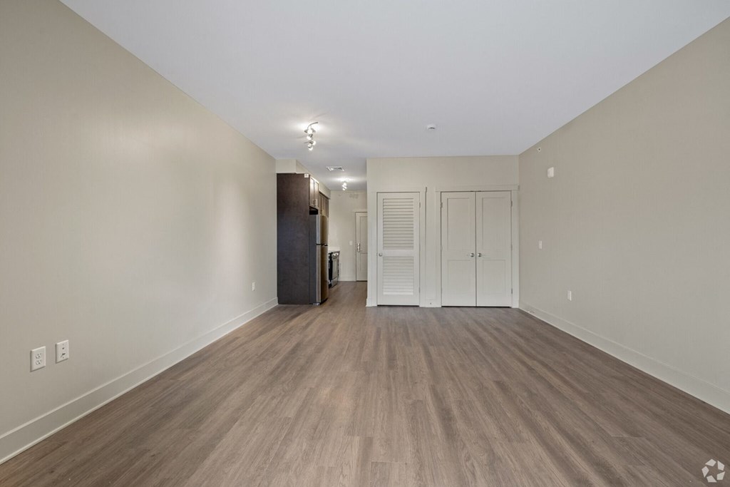 A room with wooden flooring and white walls.