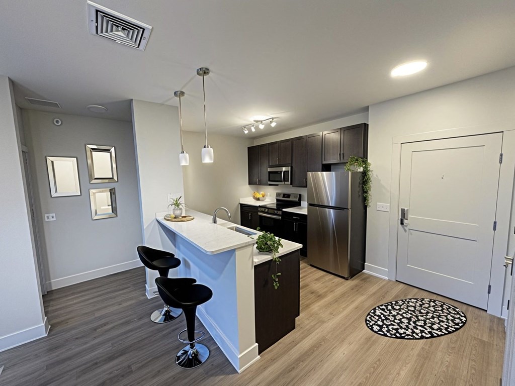 A kitchen with a white counter top and a refrigerator.