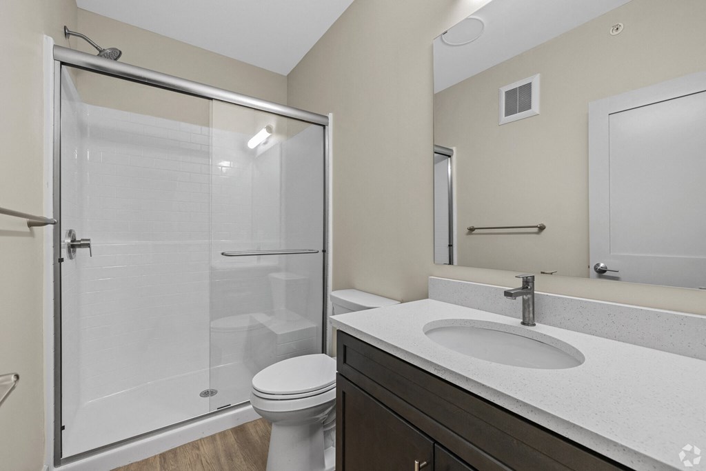 A bathroom with a toilet, sink, and shower.