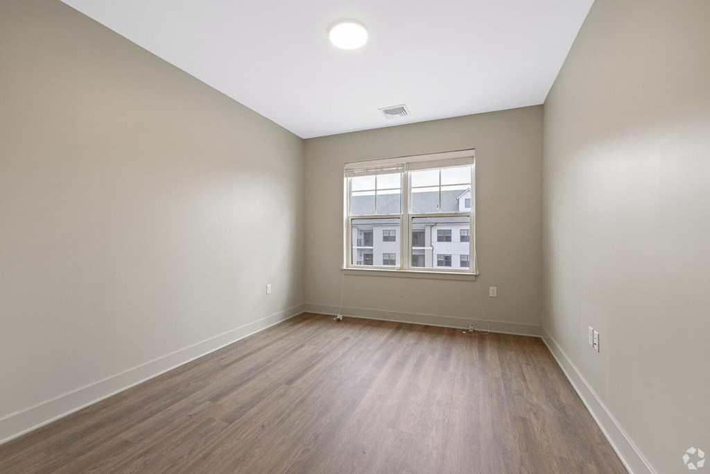 A room with wooden flooring and a window.