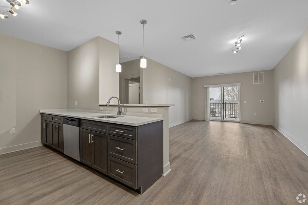 A spacious kitchen with dark wood cabinets and a white countertop.
