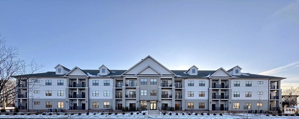 A large, multi-story residential building with a flat roof and multiple balconies.